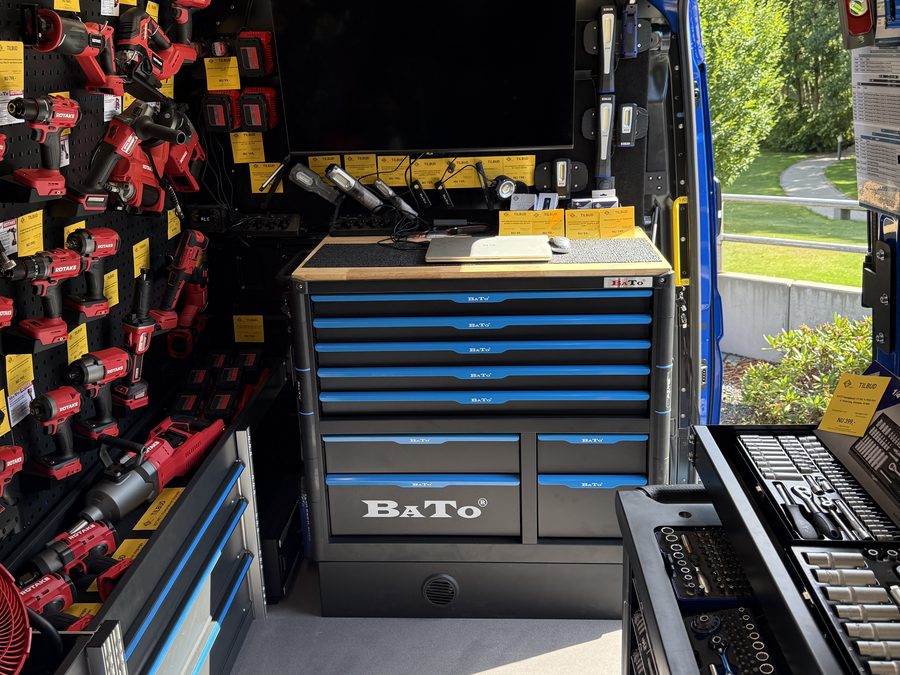 Indvendigt i BATO Demo Bus med vaerktoejsvogn, arbejdsbord og skaerm